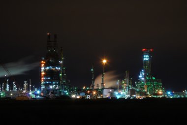 Refinery illuminated at night clipart