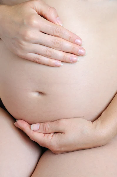 Mãos amorosas segurando barriga grávida — Fotografia de Stock