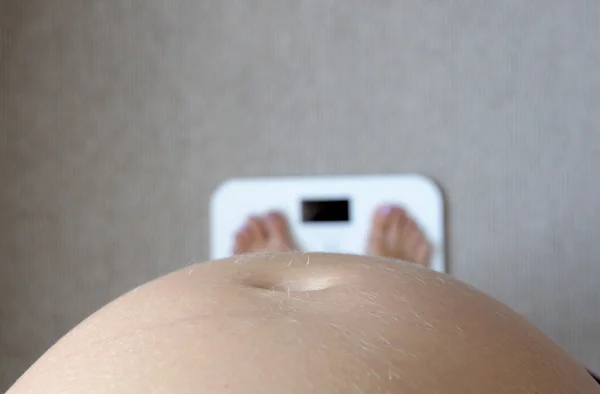 Pregnant woman on the balance — Stock Photo, Image