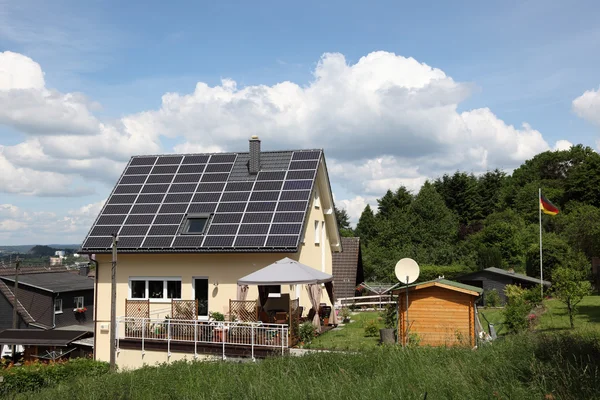 Hemtrevligt hus med solpaneler på taket — Stockfoto