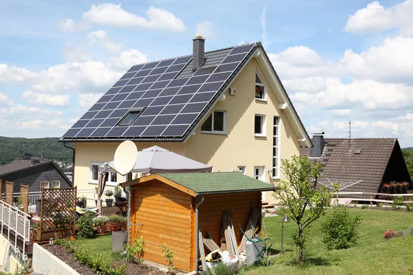 Casa com painéis fotovoltaicos no telhado — Fotografia de Stock
