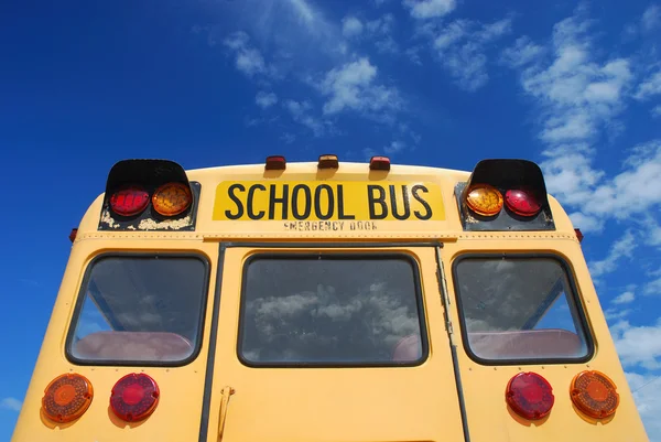 Gul skolbuss mot blå himmel — Stockfoto