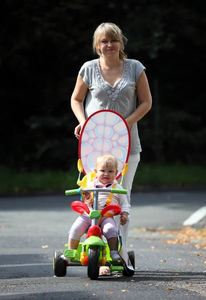 Moeder wandelingen met kleine dochter op fiets — Stockfoto