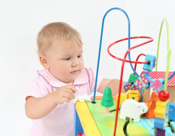Милая девочка играет с красочными игрушками — стоковое фото