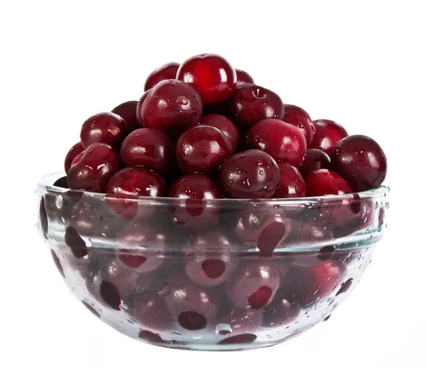 Красные вишни в стеклянной тарелке — стоковое фото