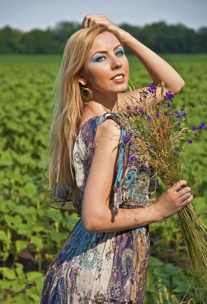 Frau mit wilden Blumen an einem Sommertag — Stockfoto