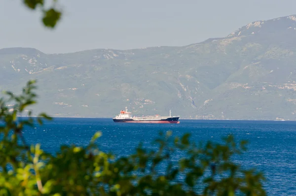 Nákladní loď poblíž mountain pobřeží — Stock fotografie