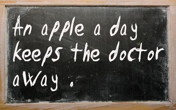 "Ein Apfel am Tag hält den Arzt fern "steht auf einer Tafel geschrieben. — Stockfoto