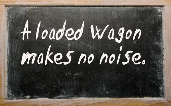 "Een beladen wagon maakt geen lawaai "geschreven op een Blackboard — Stockfoto