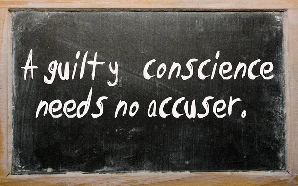 "A guilty conscience needs no accuser" written on a blackboard — Stock Photo, Image