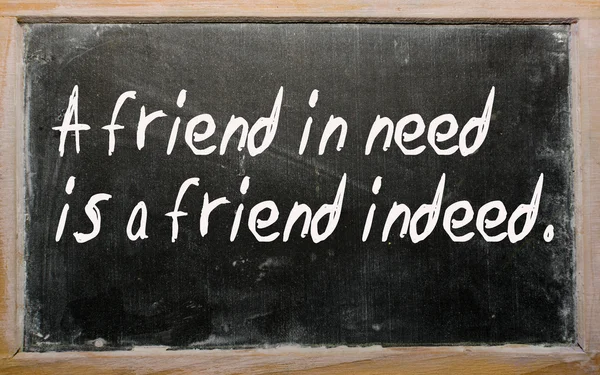 "Un amigo necesitado es un amigo de hecho "escrito en una pizarra — Foto de Stock