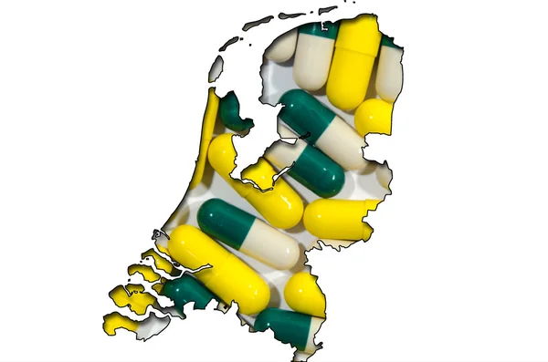 Outline map of Netherlands with pills in background — Stock Photo, Image