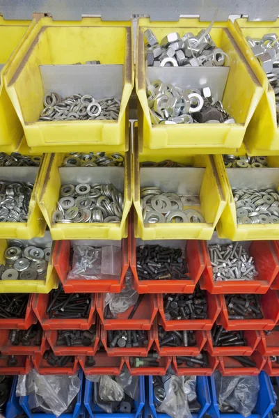 stock image Screws and nuts in colored boxes