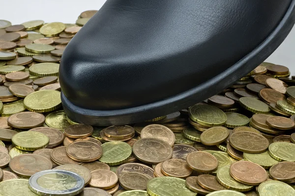 Zapato negro caminando sobre dinero —  Fotos de Stock