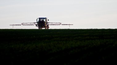 Tractor spraying agricultural pesticide clipart