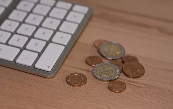 Ahşap masa üzerinde klavye ve euro coins — Stok fotoğraf