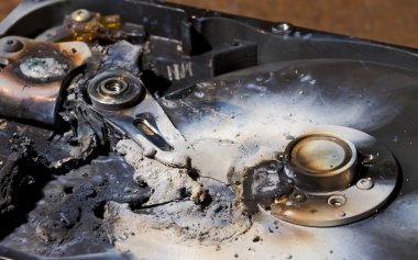 Destroyed hard drive in close up view clipart