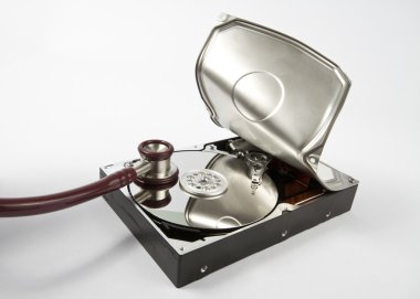 Opened hard disk with stethoscope on grey background clipart