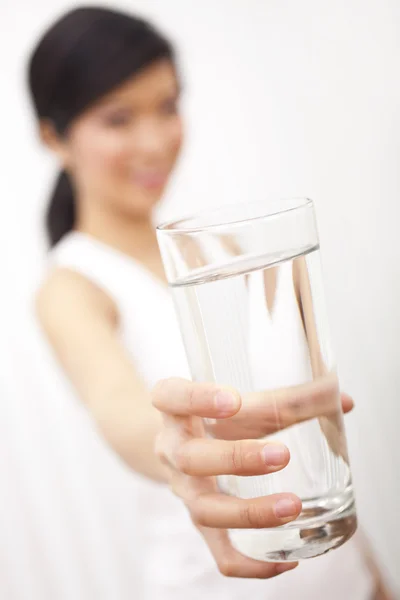 Азиатская китаянка держит стакан чистой воды перед камерой — стоковое фото