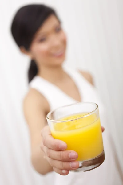 Азиатская китаянка держит стакан апельсинового сока на камеру — стоковое фото