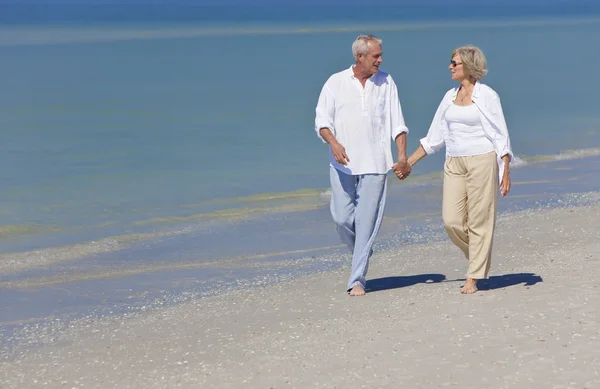 Щаслива пара старший, ходьба, тримаючись за руки на пляжі — стокове фото