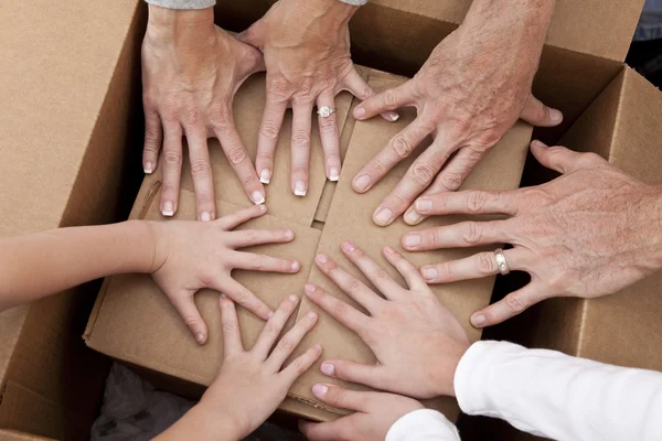 Семейные руки распаковывают коробки — стоковое фото