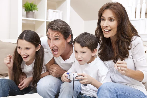Familia feliz divirtiéndose jugando videojuegos de consola —  Fotos de Stock