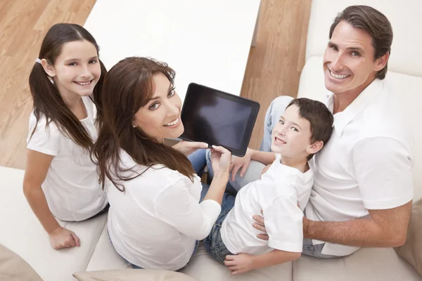 Família feliz se divertindo usando o computador tablet em casa — Fotografia de Stock