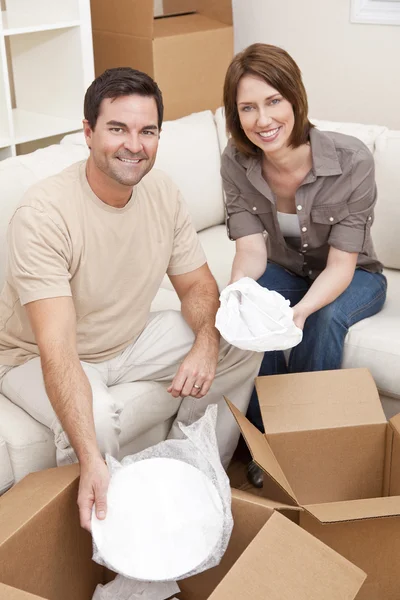 Glückliches Paar beim Auspacken oder Packen von Kartons beim Umzug — Stockfoto