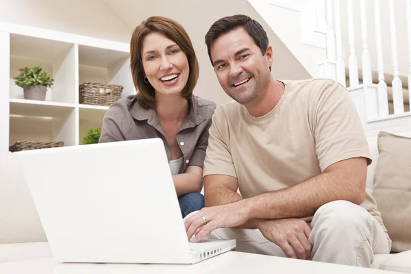 幸福的男人女人对夫妇在家中使用的膝上型计算机 — 图库照片