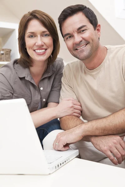 Ευτυχισμένο ζευγάρι χρησιμοποιώντας φορητό υπολογιστή στο σπίτι — Φωτογραφία Αρχείου