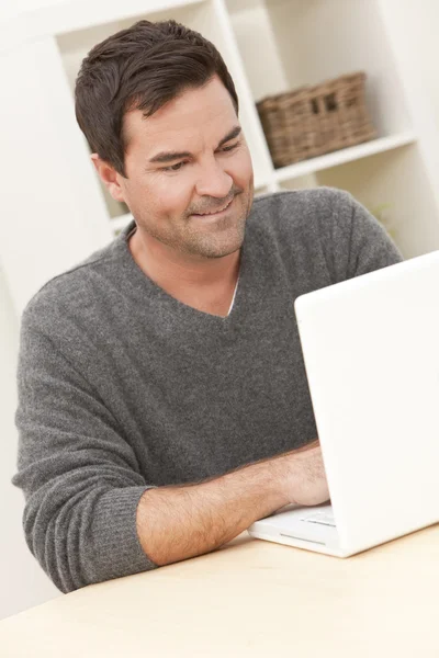 Hombre usando el ordenador portátil en casa — Foto de Stock