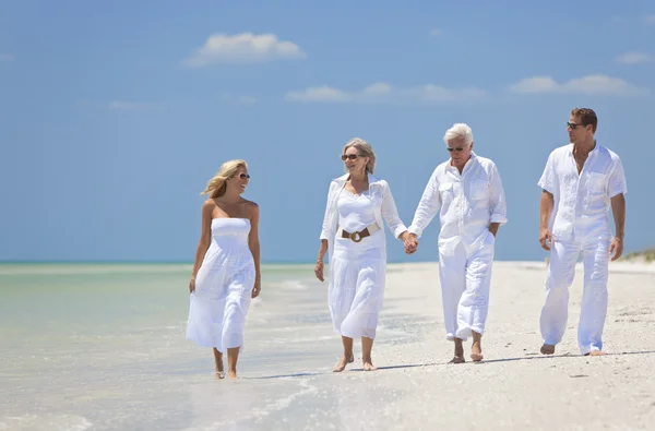 Duas gerações de casais de família caminhando na praia tropical — Fotografia de Stock