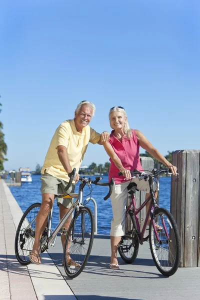 Felice coppia di anziani in bicicletta su un fiume — Foto Stock