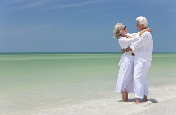 Gelukkige senior paar omarmen op een tropisch strand — Stockfoto