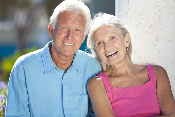 Feliz pareja de ancianos sonriendo afuera bajo el sol — Foto de Stock