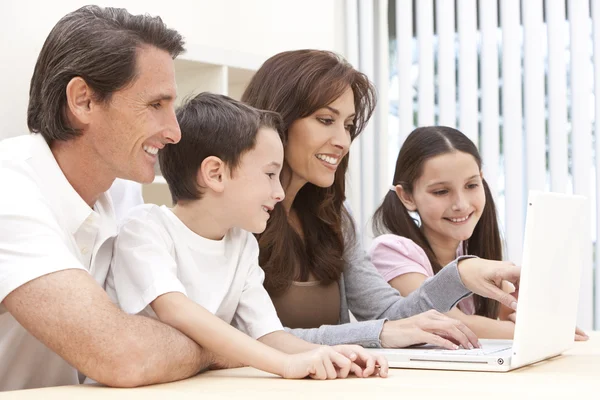 Famiglia seduto utilizzando computer portatile a casa — Foto Stock