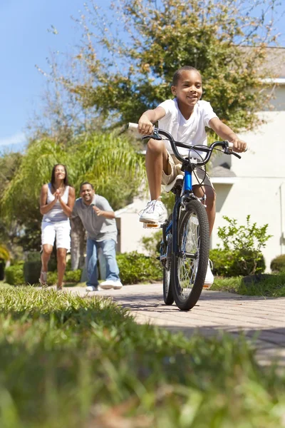 Αφρικανική αμερικανική οικογένεια με αγόρι ιππασία ποδήλατο & ευτυχείς γονείς — Φωτογραφία Αρχείου