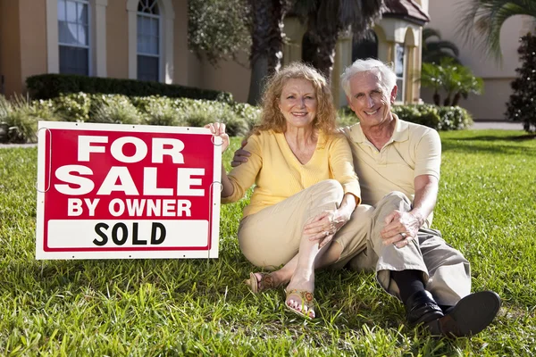 Ανώτερος ζευγάρι με προς πώληση πωλούνται από ιδιοκτήτη σημαδιού σπιτιών — Φωτογραφία Αρχείου