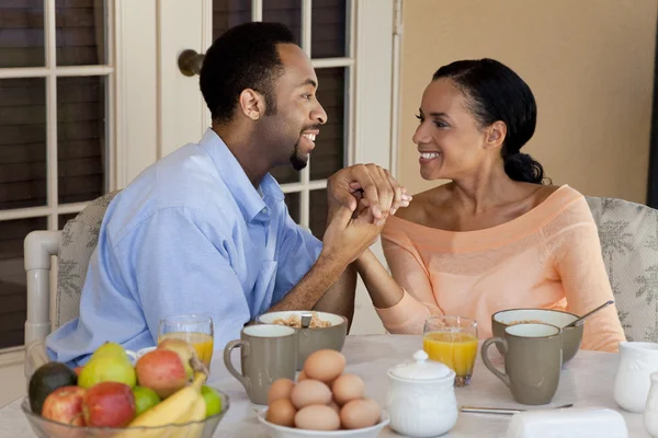 Feliz casal afro-americano segurando as mãos no café da manhã saudável — Fotografia de Stock