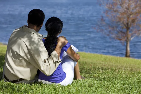 Vista posteriore della coppia afroamericana seduta vicino al lago — Foto Stock