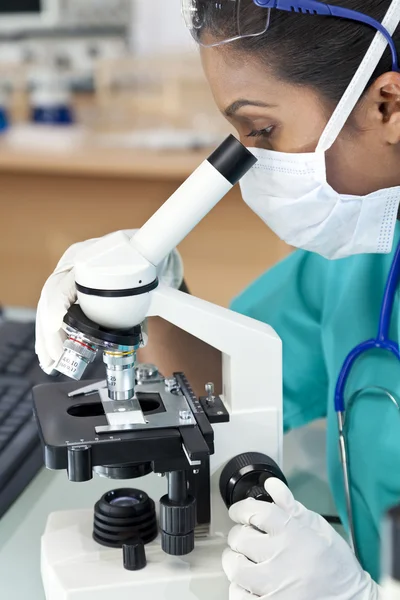 Азиатская женщина-врач или ученый с помощью микроскопа в лаборатории — стоковое фото