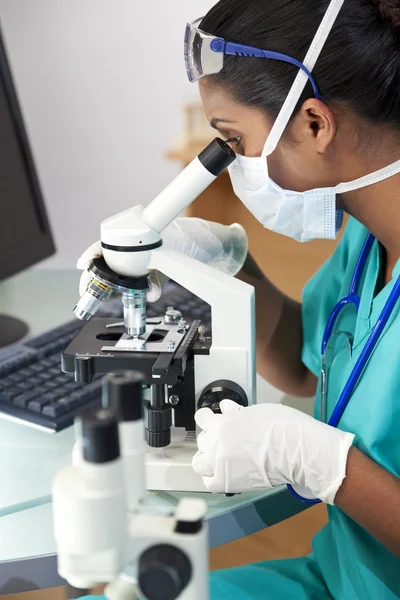 Asiatische Ärztin oder Wissenschaftlerin unter dem Mikroskop im Labor — Stockfoto