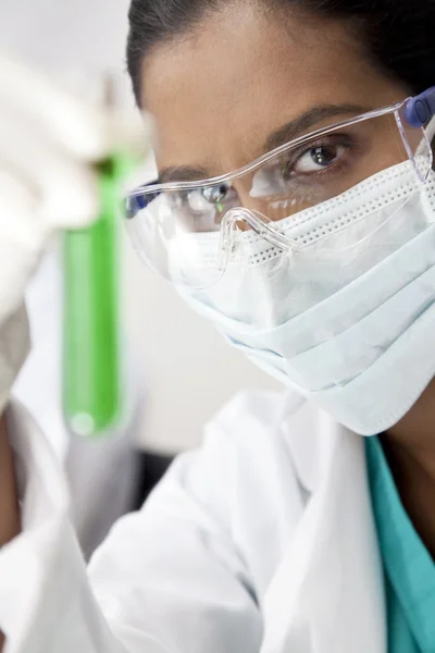 Asiatiska kvinnlig vetenskapsman med laboratorium provrör av grön soluti — Stockfoto
