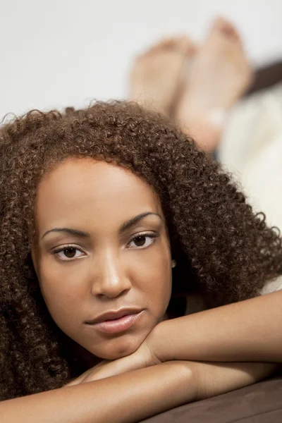 Hermosa raza mixta afroamericana chica acostándose en Settee —  Fotos de Stock