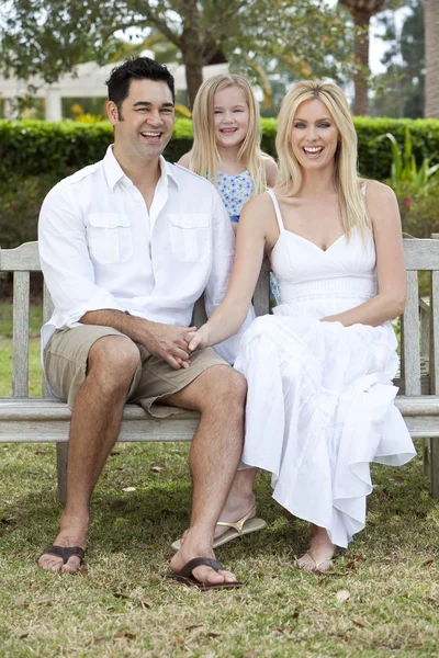Gelukkig moeder vader dochter familie zittend op een bankje — Stockfoto