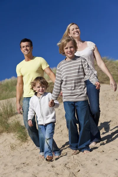 Moeder, vader en twee jongens lopen plezier op strand — Stockfoto