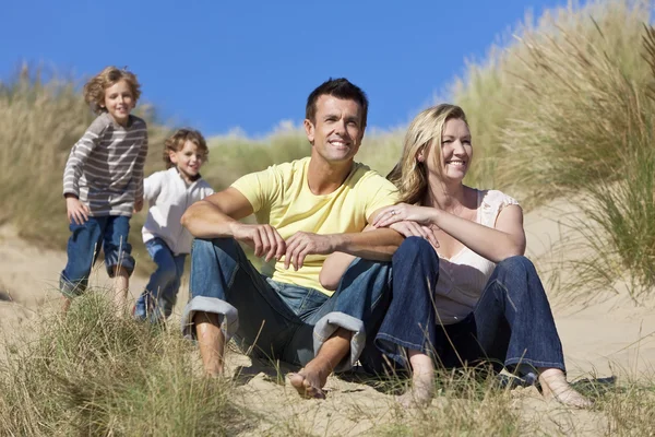 Rodina sedí na pláži baví — Stock fotografie