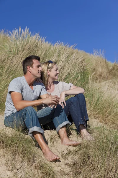 Romantikus férfi és nő pár ül össze a strandon — Stock Fotó
