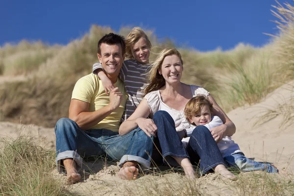 Mãe, pai e dois meninos sentados se divertindo na praia — Fotografia de Stock